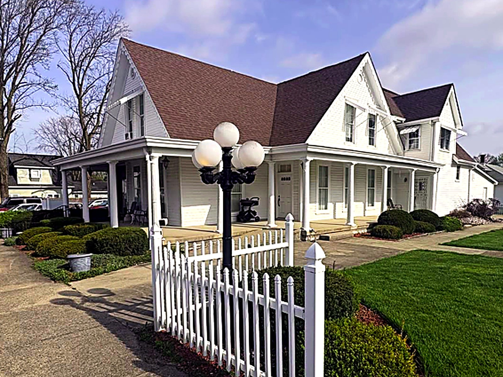 The Glenn E. George Funeral Home building with white picket fence